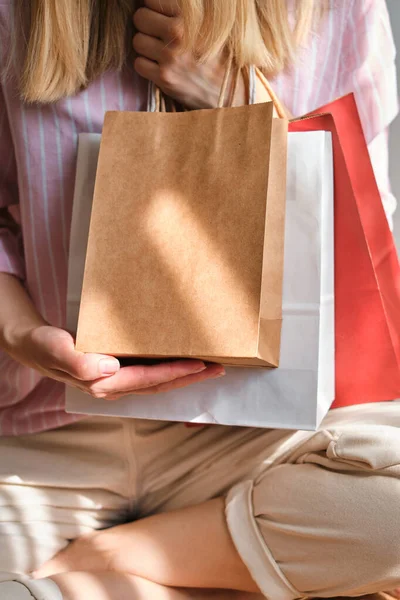 Woman holding in hand shopping package. Paper bag. Sale in store. Beautiful young girl after shopping in fashion shop. Customer buy present online. Black friday sale. Holiday special offer, discount