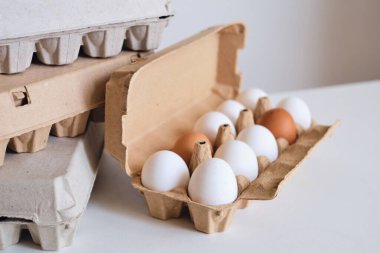 Tavuk yumurtalı karton kutular. Masada pişmemiş yumurtalarla kutular. Doğal organik tarım ürünü. Paskalya tatiline hazırlanıyorum. Taze yemek teslimatı, karton paket. Yemek pişirmek için ham malzeme.