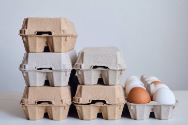 Tavuk yumurtalı karton kutular. Masada pişmemiş yumurtalarla kutular. Doğal organik tarım ürünü. Paskalya tatiline hazırlanıyorum. Taze yemek teslimatı, karton paket. Yemek pişirmek için ham malzeme.