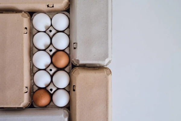 Cardboard boxes with chicken eggs. Boxes with uncooked eggs in table. Natural organic farm product. Preparing for Easter holiday. Fresh food delivery, carton package. Raw ingredient for cooking eat