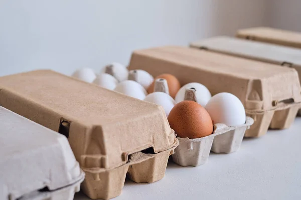 Cardboard boxes with chicken eggs. Boxes with uncooked eggs in table. Natural organic farm product. Preparing for Easter holiday. Fresh food delivery, carton package. Raw ingredient for cooking eat