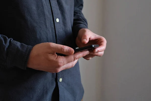 A man holding a smartphone in his hands. Businessman with a trendy portable gadget. Modern technology, wireless Internet. Mobile device for work and leisure. Freedom lifestyle, freelance work