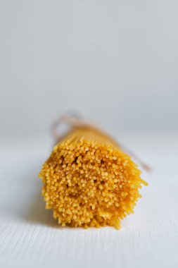 Mutfak masasında pişmemiş spagetti paketi. Geleneksel İtalyan makarnası, sağlıklı organik yiyecekler. Yemek için ham malzeme. Aile için ev yapımı lezzetli yemekler pişirmek. Durum buğday spagettisi yakın plan.