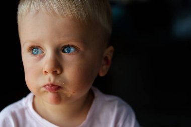Mavi gözlü sarışın bir çocuğun portresi.