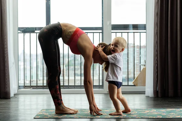 Giovane Madre Pratica Yoga Casa Con Suo Bambino Foto Stock