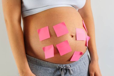 Çıkartmalı hamile bir kadının karnı.