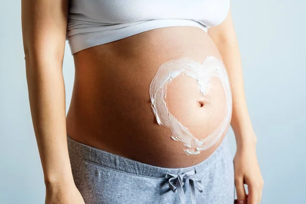 Futura Mãe Posando Com Sinal Coração Feito Creme Hidratante Barriga — Fotografia de Stock