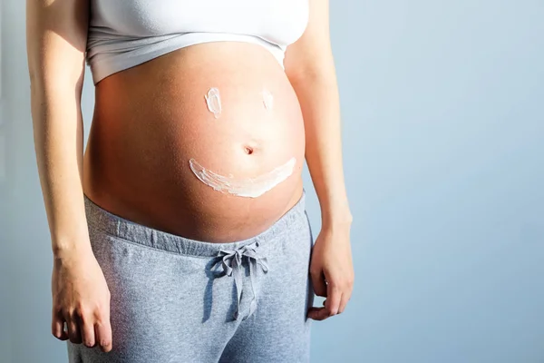 Barriga Uma Mulher Grávida Close Com Creme — Fotografia de Stock