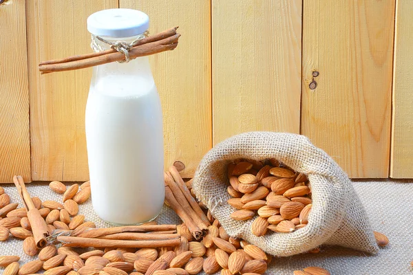 Susu almond dengan almond di atas meja kayu — Stok Foto