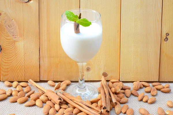 Миндальное молоко с миндалем на деревянном столе — стоковое фото