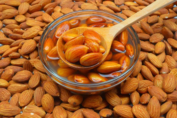 Almond mentah berendam dalam semangkuk air putih — Stok Foto