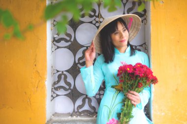 Vietnamca kız geleneksel kıyafet tutun çiçekler parlak.