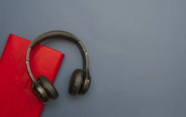 Fülhallgató és egy piros notebook Stock Kép