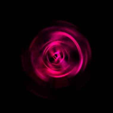 Siyah arka planda izole edilmiş dönen ışık ışınları. Dairesel hareketle parlayan renkli ışık parçacıklarının grafiksel 2d çizimi.