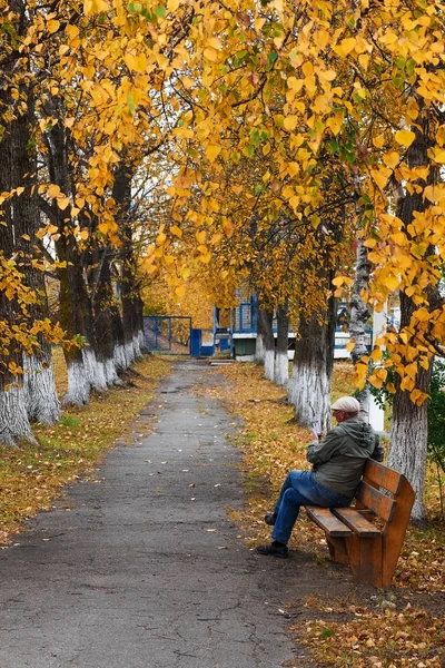 Muž sedí na lavičce — Stock fotografie