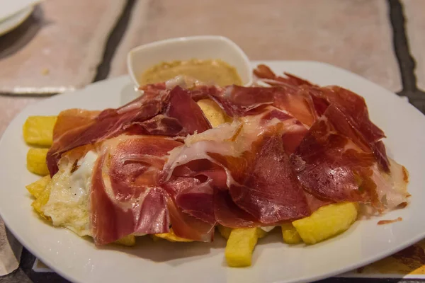 Kızarmış patatesle servis edilen geleneksel İspanyol sahanda yumurta.