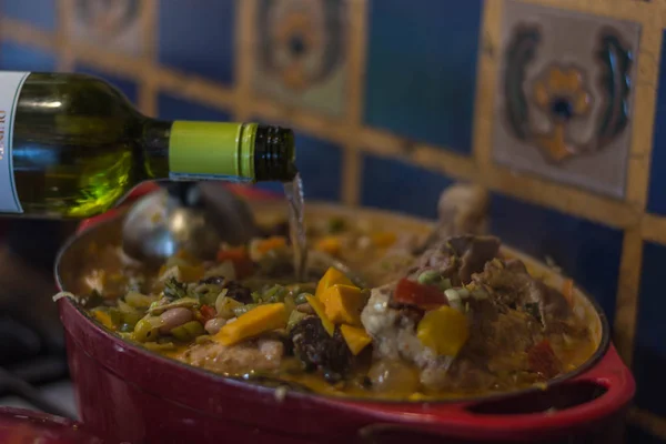 Gießen Weißwein in den Topf, in dem ein typisches kolumbianisches Gericht gekocht wird — Stockfoto