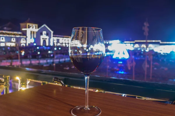 Glas Wein mit Villa de leyva Hauptplatz mit Weihnachtsbeleuchtung im Hintergrund — Stockfoto