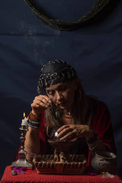 Zigeunerwaarzegster of esoterisch orakel met een rokend stuk hout en een magische kristallen bol — Stockfoto