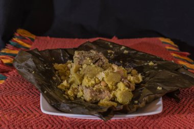 Beyaz bir tabak ve geleneksel kırmızı kumaşla Kolombiya Tamal 'ı açıldı.