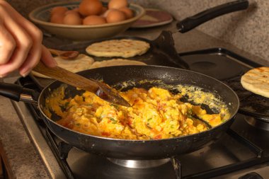 Ev yapımı arepa ve soğan ve domatesli yumurta. Tipik Kolombiya yemeği Criollo yumurtaları.