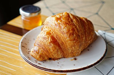 Turuncu j ile seramik plaka üzerinde taze pişmiş kruvasanlar, closeup