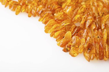 beyaz zemin üzerinde kehribar kolye