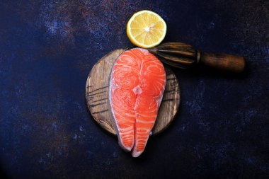 Bir koyu arka plan en iyi görünümde limonlu Çiğ somon biftek.