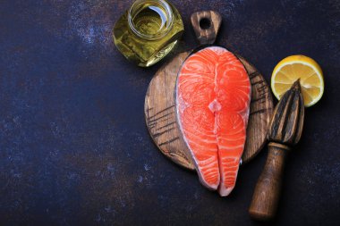 Koyu arka plan üstten görünüm üzerinde limon ve zeytin yağı ile Çiğ somon biftek.
