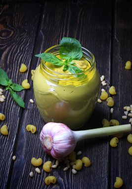 Pesto soslu makarna üzerine koyu ahşap arka plan için. Sedir fındık, fesleğen, sarımsak, zeytinyağı, peynir