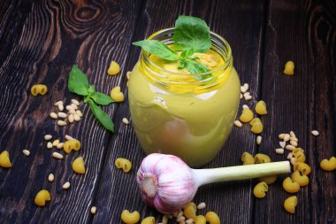 Pesto soslu makarna üzerine koyu ahşap arka plan için. Sedir fındık, fesleğen, sarımsak, zeytinyağı, peynir