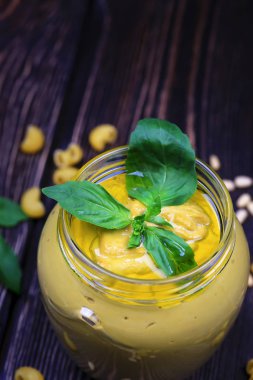 Pesto soslu makarna üzerine koyu ahşap arka plan için. Sedir fındık, fesleğen, sarımsak, zeytinyağı, peynir