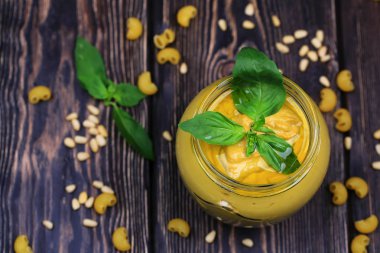 Pesto soslu makarna üzerine koyu ahşap arka plan için. Sedir fındık, fesleğen, sarımsak, zeytinyağı, peynir