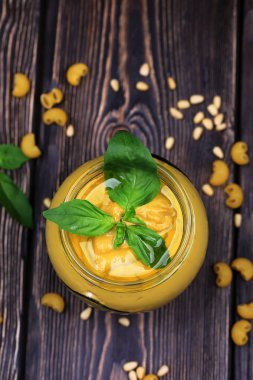 Pesto soslu makarna üzerine koyu ahşap arka plan için. Sedir fındık, fesleğen, sarımsak, zeytinyağı, peynir