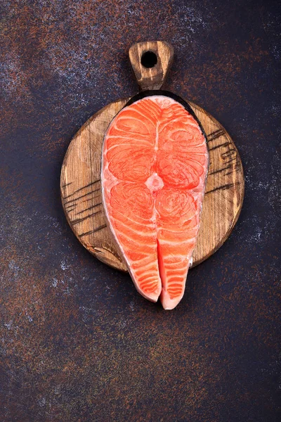 Karanlık bir arka plan üst görünümü üzerinde Çiğ somon biftek