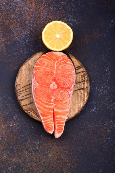 Bir koyu arka plan en iyi görünümde limonlu Çiğ somon biftek.