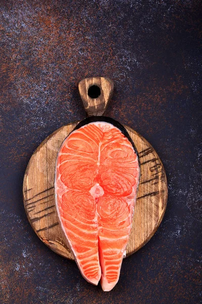 Karanlık bir arka plan üst görünümü üzerinde Çiğ somon biftek
