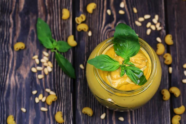 Pesto sauce for pasta on a dark wooden background. Cedar nuts, basil, garlic, olive oil, cheese — Stock Photo, Image