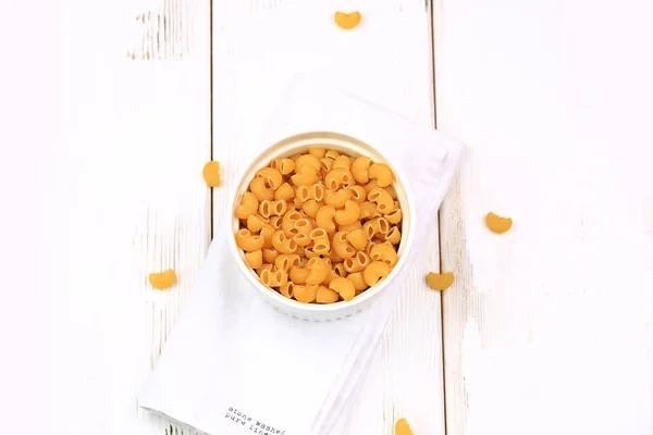 Raw dry pasta on a white wooden background — Stock Photo, Image