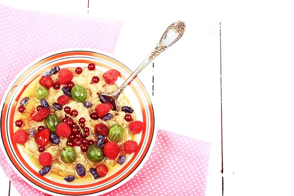 Frühstück Haferflocken mit Beeren und Honig auf weißem Holzbackgro — Stockfoto