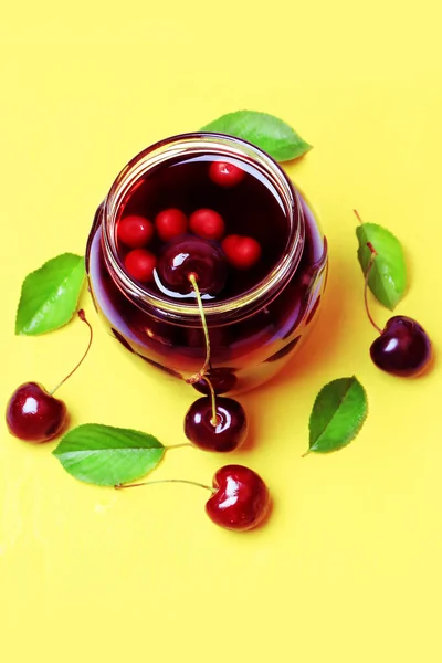 Cherry juice on a yellow wooden background flat top over head vi — Stock Photo, Image