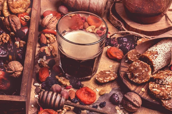 Кофе и сухофрукты. Здоровая пища, сушеные абрикосы, орехи, домашние сладости из овсянки. Ретро-тонированный фон — стоковое фото
