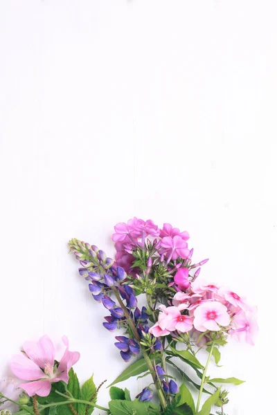 Flores de primavera em um fundo de madeira branco — Fotografia de Stock