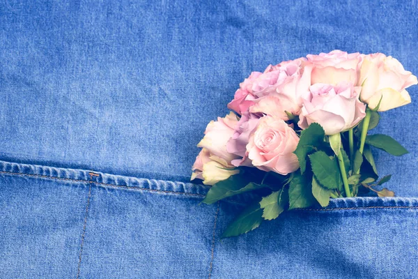 Buquê de rosas em um avental de cozinha de ganga — Fotografia de Stock