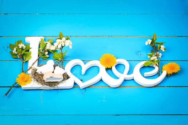 Wortliebe auf Holzgrund mit Frühlingsblumen. Valentinstag — Stockfoto