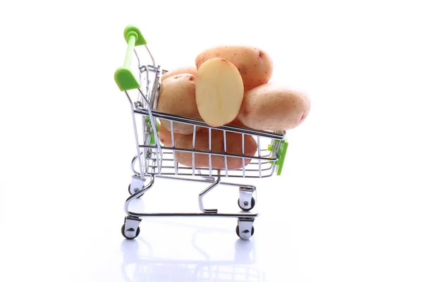 Batatas cruas em um carrinho de compras isolado em fundo branco — Fotografia de Stock