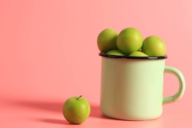 Yeşil kiraz eriği pembe arka planda bir diş minesi bardağında. Yaratıcı minimalist stil. sağlıklı yiyecekler