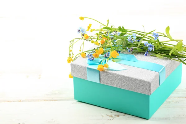 Flores silvestres na caixa de presente no fundo de madeira branco — Fotografia de Stock