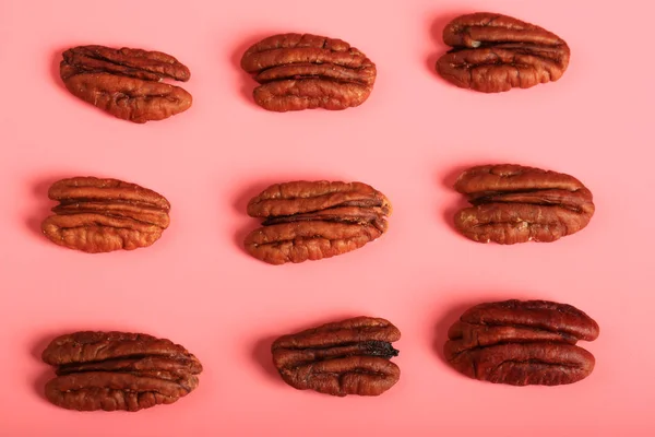 Pecan nuts on a pink background. creative minimalist style. healthy food — Stock Photo, Image