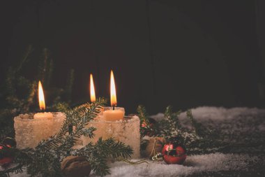 Yeni yıl geçmişi. Karda köknar ağacı yanan Noel mumları